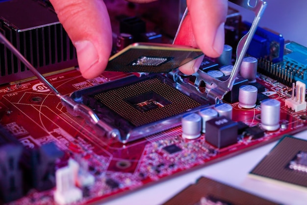 A man's hand inserts a processor into the motherboard chipset