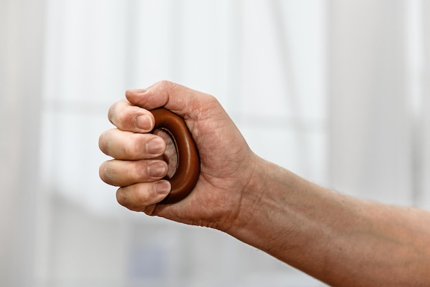 Man's hand squeezes the expander closeup