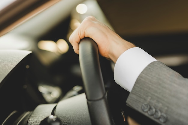 Man's hand on steering wheel in the car