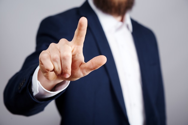 Man's hand wearing suit showing a sign at studio