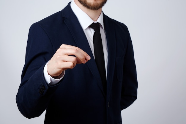 Man's hand wearing suit showing a sign  wall, business concept, gestures, holding, mock up.