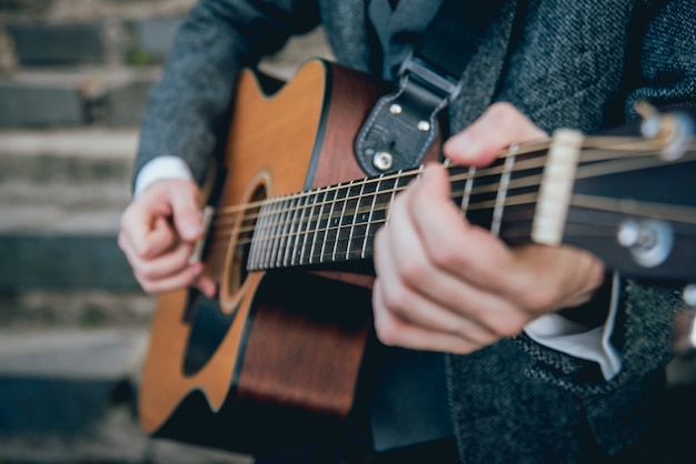 Man's hands playing acoustic guitar. Authentic background.