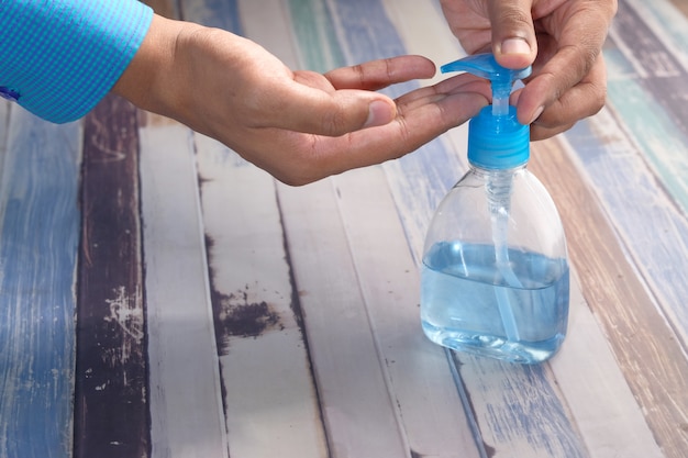 Man's hands using hand sanitizer gel, close up