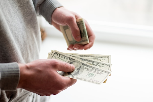 Man's hands with dollars on white background.