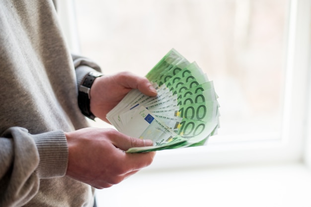 Man's hands with euro on white background. 