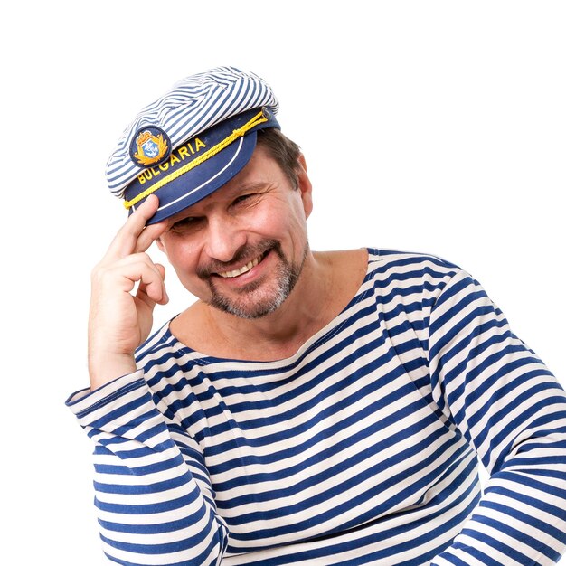 A man sailor in a cap with a smoking pipe in front of a white background