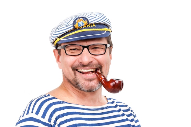 A man sailor in a cap with a smoking pipe in front of a white background