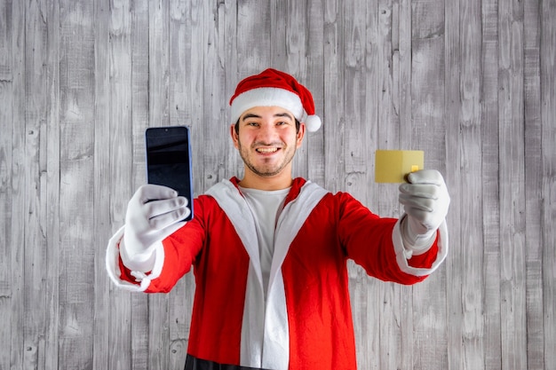 Man in Santa Claus costume with a cell phone and a credit card