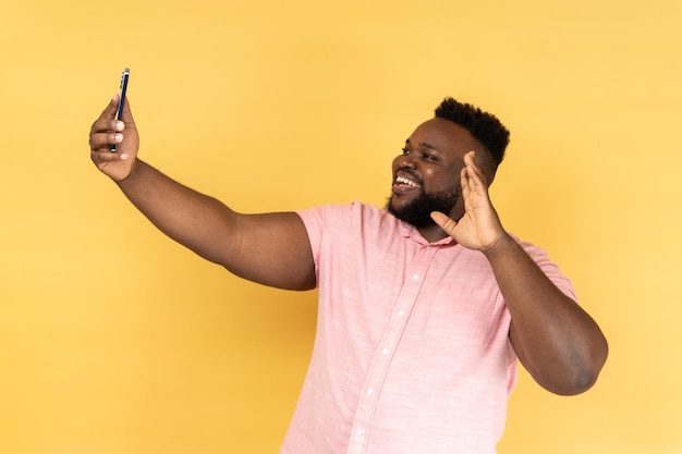 Man saying hi making video call using smartphone smiling with toothy smile 4g connection