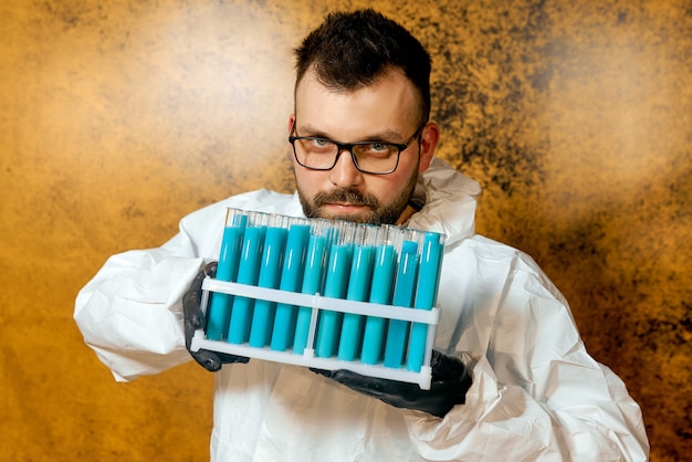 A man Scientist in a protective suit with flasks in his hands with a blue vaccine