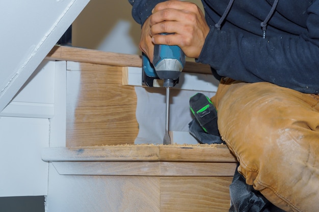 Man screws stairs with drill in park