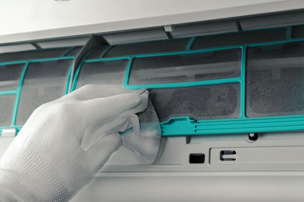 The man serves the air conditioner Checking the filter for dirt