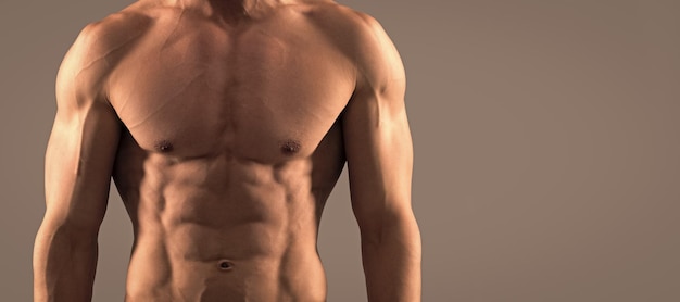 Man sexy bare torso banner with copy space He is in good shape Shirtless guy in sports shorts Fit guy grey background Sporting man