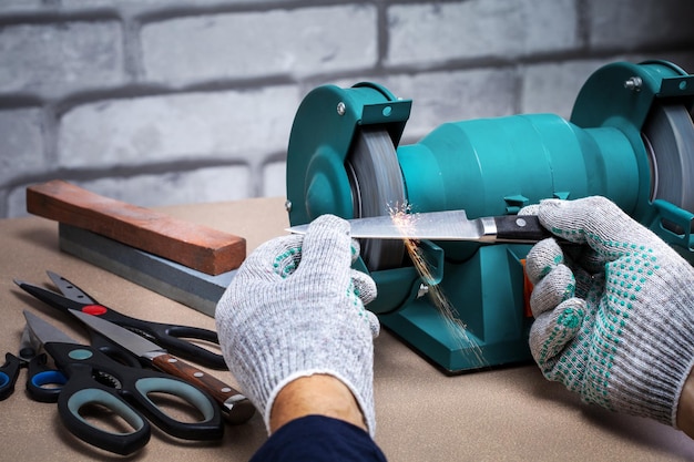 Man sharpening the knife with a electric sharpener Small business