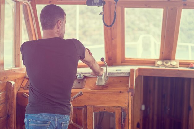 Man in the ship's deckhouse or captain at the helm Toned