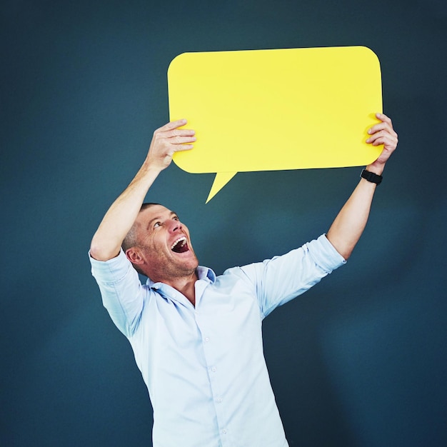 Photo man shocked and speech bubble in studio for advertising social media and information with smile male person icon and poster with mockup space for review opinion and billboard on blue background