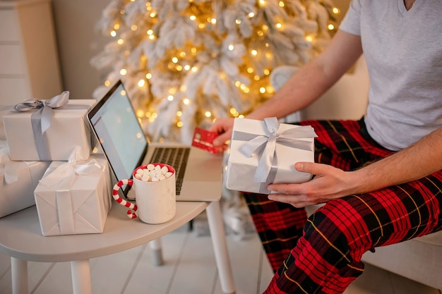 man shopping online christmas gifts on laptop