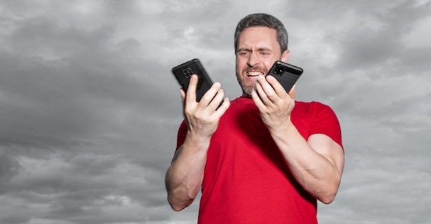 man shouting has phone talk on sky background man has phone talk outdoor man has phone talk wear red tshirt photo of man has phone talk