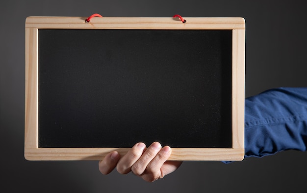 Man showing empty school blackboard