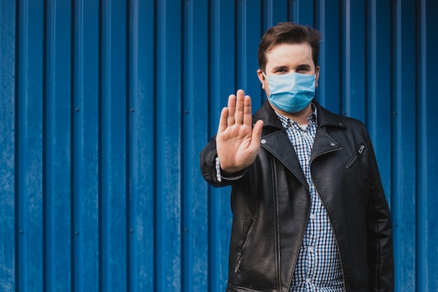 Man showing gesture stop. man wears protective mask against infectious diseases and flu.