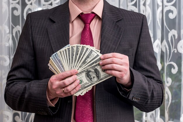 Man showing his profit in dollar banknotes