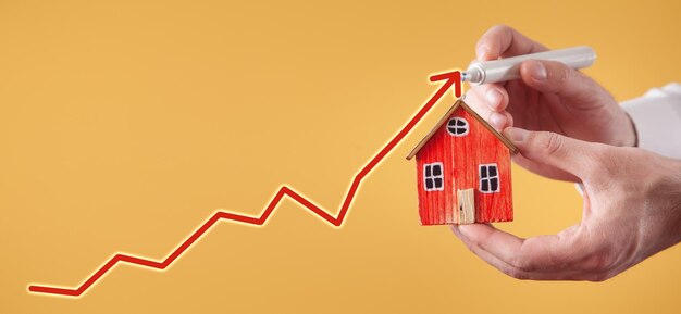 Man showing house model with a growth arrow