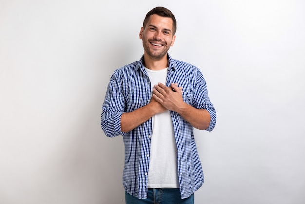 Man showing love gesture touches his arms on chest in studio