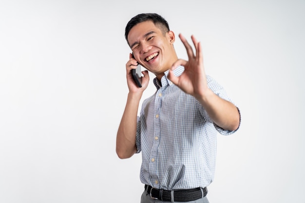 Man showing okay gesture while making phone call