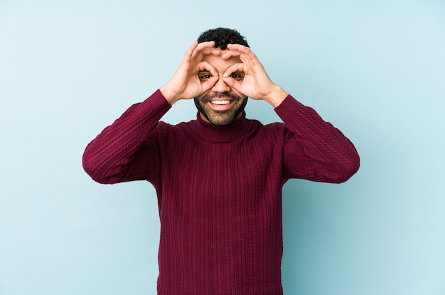 Man showing okay sign over eyes