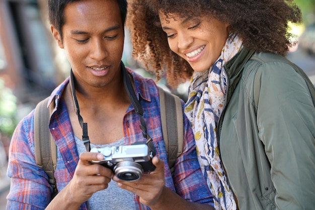 Man showing pictures to girlfriend on camera screen    