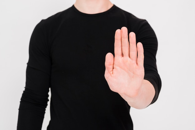 Man showing stop gesture over white background