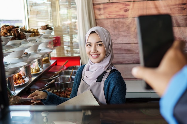 A man shows his order from mobile to waiter