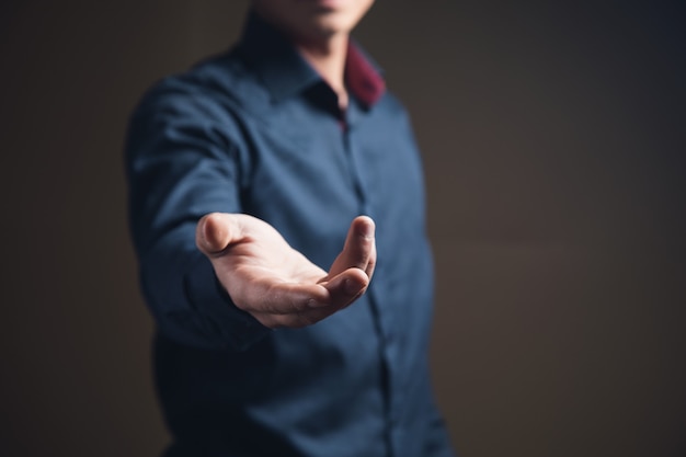 Man shows open palm on brown surface