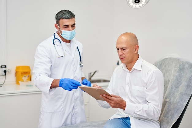 Man signing contract with doctor at hospital