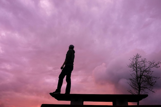 man silhouette on the wooden table with a beautiful sunset background