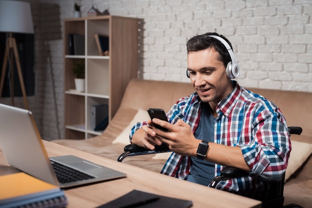 A man sits at home and listens to music on headphones.