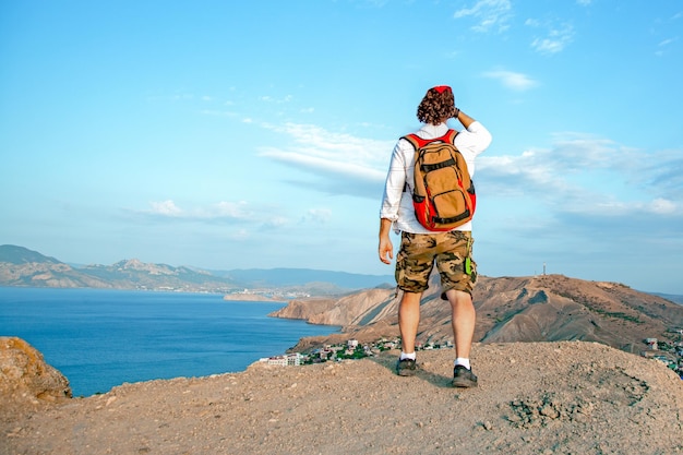 A man sits overlooking a panoramic view of a beautiful coastline