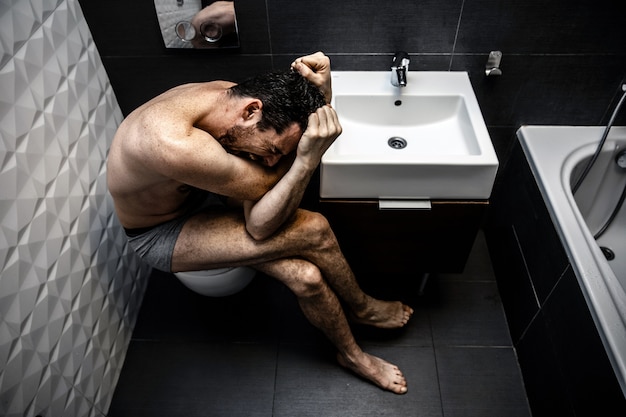 man sitting in the bathroom