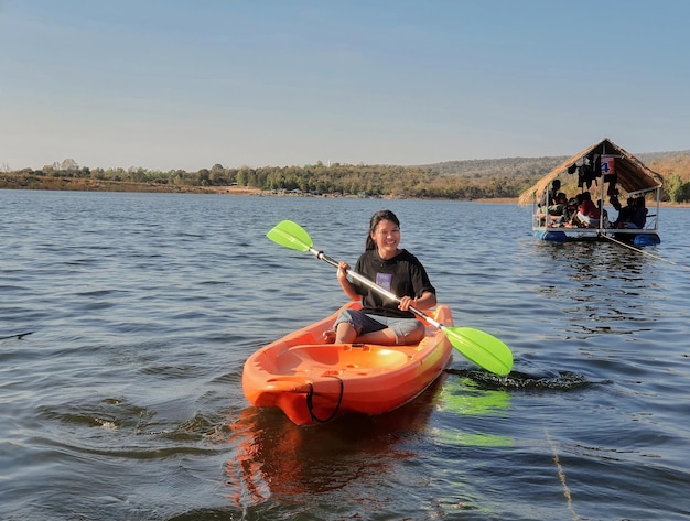 Photo man sitting in boat on lake against sky