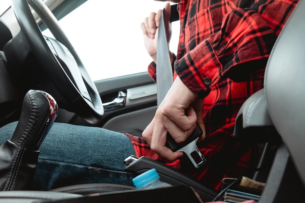 Man sitting on car seat fastening seat belt for safety preventing the danger of accident on road