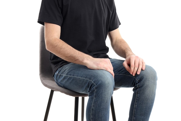 Man sitting on chair, isolated on white background. Hemorrhoids concept