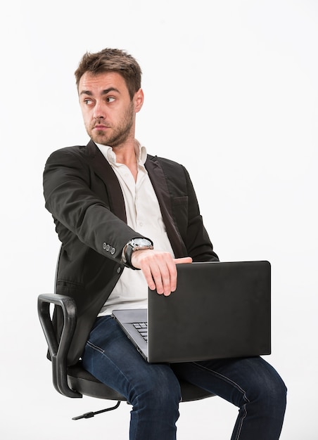 Man sitting on a chair while holding a laptop