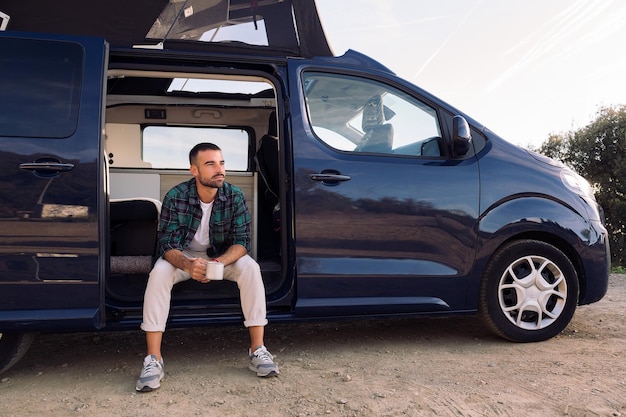 Man sitting in the door of his camper van