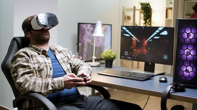 Man sitting on gaming chair taking off his vr headset. Game over for male gamer with long hair.