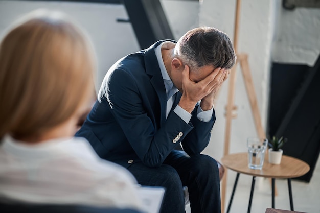 Man sitting at the psychologist and speaking about his problems