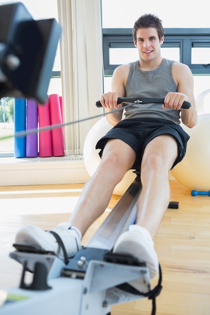 Man sitting at the row machine smiling 