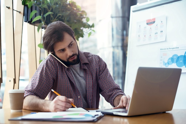 Man sitting at the table at creative stylish office working busy