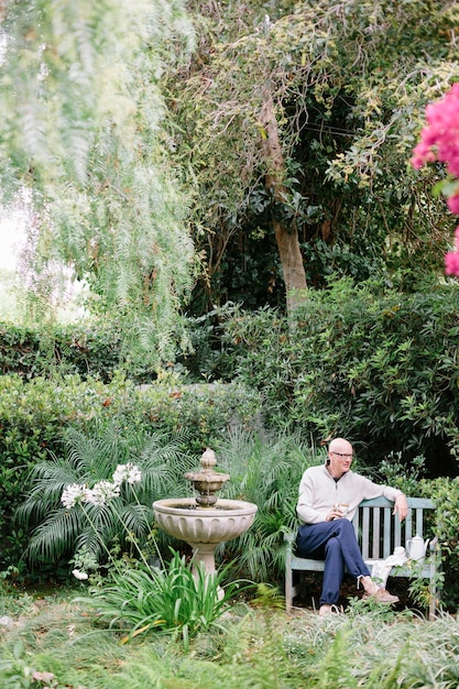 Man sitting on a wooden bench in a garden taking a break