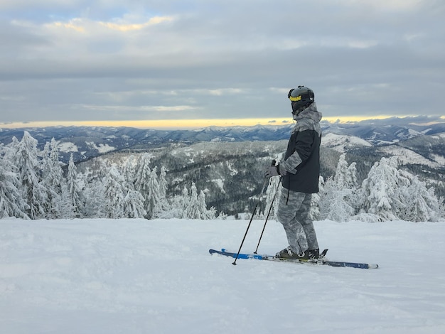 Man skier enjoying sunset above the mountains