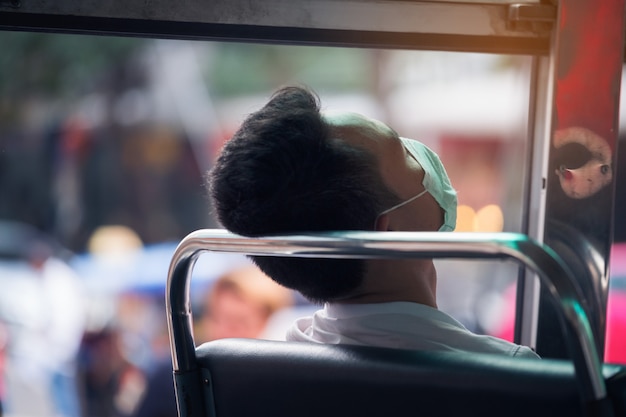 Man sleeping after be tried from hard work in public omnibus of bangkok in Bangkok, Thailand